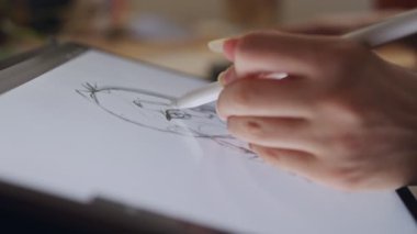 Tablet bilgisayar ve elektronik kalem kullanan genç bir kız çiziyor.