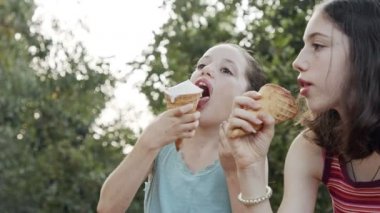 Çocuklar birlikte dondurma yiyor, eğleniyor ve gülüyorlar.