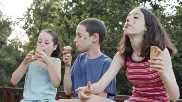 Niños comiendo helado juntos, disfrutando y riendo — Vídeos de Stock
