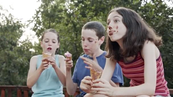 Niños comiendo helado juntos, disfrutando y riendo — Vídeos de Stock