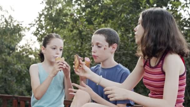 Niños comiendo helado juntos, disfrutando y riendo — Vídeos de Stock