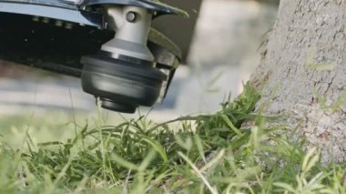 Bahçede yabani ot ve ot kesen bir tel budayıcının yavaş hareketi