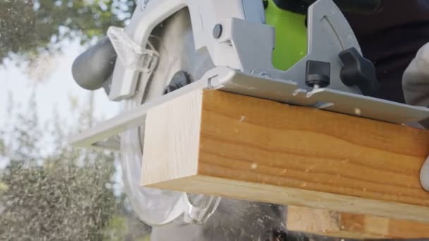 Slow motion of a round saw cutting through wood with dust flying — Stock Video