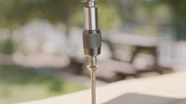 Tahtaya vida saplamak için elektrikli tornavida kullanan bir adamın yavaş hareketi.