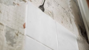 Döner çekicin yavaş hareketi seramik fayansları duvardan kırıyor.