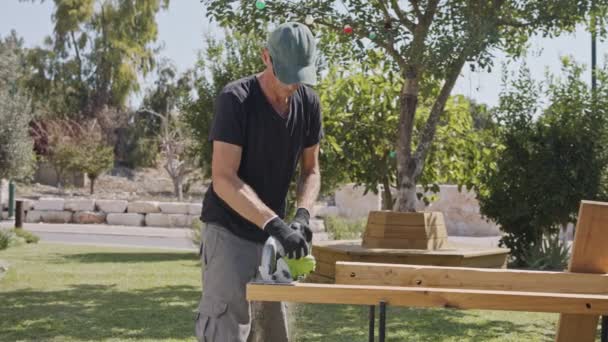 Movimento lento de um homem usando uma serra redonda para cortar madeira — Vídeo de Stock