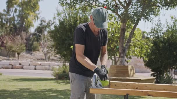 Movimento lento de um homem usando uma serra redonda para cortar madeira — Vídeo de Stock