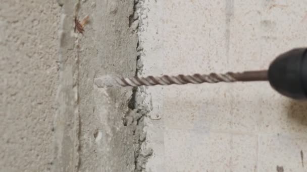 Mand boring hul i betonvæg. Reparation arbejder indendørs i slowmotion – Stock-video