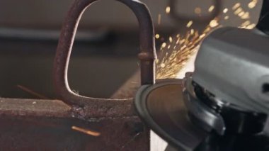 İş sırasında kıvılcımlar uçuşurken metal öğütücünün yavaş hareketi