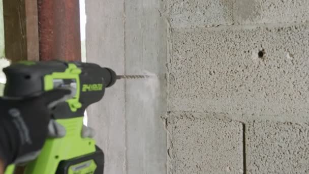 Hombre perforando el agujero en la pared de hormigón. Trabajos de reparación en interiores en cámara lenta — Vídeo de stock