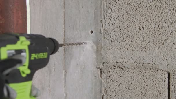 Człowiek wierci dziurę w betonowej ścianie. Remont w pomieszczeniach w zwolnionym tempie — Wideo stockowe