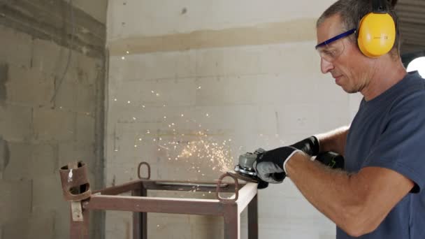 Mann mit einem Metallschleifer auf einem metallenen Gegenstand mit Funken, die in Zeitlupe fliegen — Stockvideo