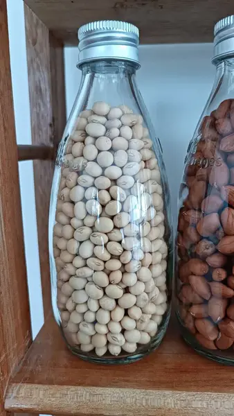 Cam şişelerde saklanmış soya tohumu örneklerinin portresi.
