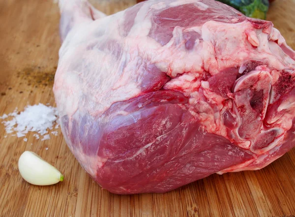 Fresh and raw meat. Leg of lamb on wood background