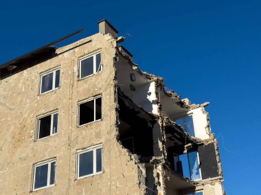 Açık mavi gökyüzü karşı kısmen yıkılmış bina.