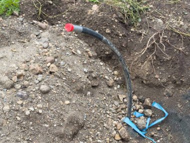 Toprak ve kayalarda açığa çıkmış yeraltı kablosu.