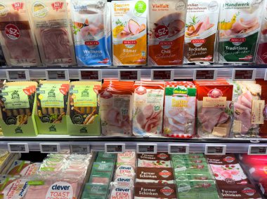 Alman süpermarketinde çeşitli paketlenmiş et ve peynirler sergileniyor.