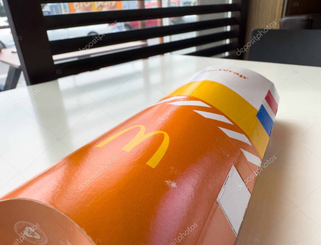 Mcdonald's french fries packaging on table in restaurant interior.