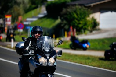 Faaker See, Avusturya - 01 Eylül 2025: Avrupa Bisiklet Haftası 'nda kasklı erkek motorcu gümüş motosiklet sürüyor, Harley-Treffen' in heyecanını yakalıyor