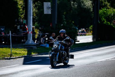 Faaker See, Avusturya - 01 Eylül 2025: Avrupa Bisiklet Haftası boyunca deri ceketli motosiklet meraklısı, Harley-Treffen 'in ruhunu yakaladı.