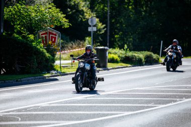 Faaker See, Avusturya - 01 Eylül 2025: Harley-Davidson motosikletli motosiklet Avrupa Bisiklet Haftası 'nda güneşli yolda giderken motosiklet kültürünün özünü yakalıyor