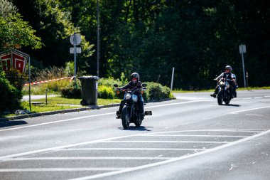 Faaker See, Avusturya - 01 Eylül 2025: Harley-Davidson bisikletli motosikletçiler Avrupa Bisiklet Haftası boyunca manzaralı bir yolda dolaşarak Harley-Treffen etkinliğinin heyecanını yakalıyorlar