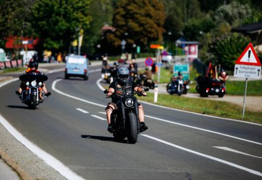 Faaker See, Avusturya - 01 Eylül 2025: Motosikletçiler Avrupa Bisiklet Haftası boyunca Harley-Davidson motosikletleri ve canlı bir çevre içeren manzaralı bir gezinin keyfini çıkarıyorlar
