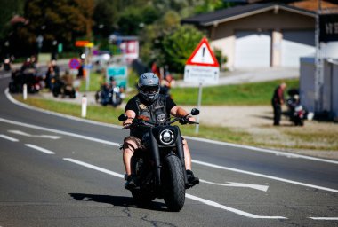 Faaker See, Avusturya - 01 Eylül 2025: Harley-Davidson 'daki erkek motosikletçi Avrupa Bisiklet Haftası boyunca güzel bir yolda seyahat ederek özgürlük ruhunu yakalıyor