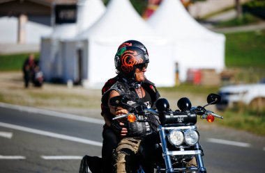 Faaker See, Avusturya - 01 Eylül 2025: Bisikletçi Avrupa Bisiklet Haftası 'nda renkli bir kask takıyor, Harley-Treffen' in hayat dolu ruhunu yakalıyor