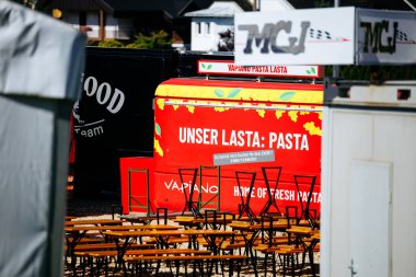 Faaker See, Avusturya - 01 Eylül 2025: Avrupa Bisiklet Haftası 'nda gıda kamyonu boş masalar ve canlı afişlerle çevrili taze makarna sunumlarına ev sahipliği yapıyor