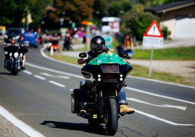 Faaker See, Avusturya - 01 Eylül 2025: Avrupa Bisiklet Haftası boyunca yeşil elbiseli motosiklet meraklısı, Harley-Treffen 'in özünü yakalıyor
