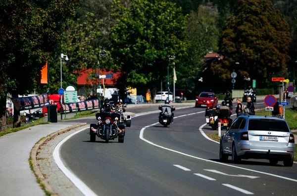 Faaker See, Avusturya - 01 Eylül 2025: Avrupa Bisiklet Haftası 'nda motosikletler, Harley-Treffen buluşmasının hareketli ambiyansını ve yoldaşlığını vurgulamak için pitoresk bir yolda ilerliyor