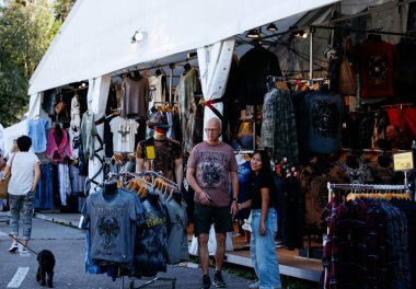 Faaker See, Avusturya - 01 Eylül 2025: Avrupa Bisiklet Haftası 'nda açık hava pazarı renkli bisikletçi kıyafetleri ve aksesuarları sergiliyor, ziyaretçileri cezbediyor ve neşeli bir ortam yaratıyor