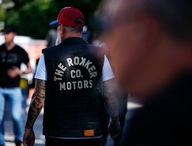 Faaker See, Avusturya - 01 Eylül 2025: Avrupa Bisiklet Haftası 'nda Rokker Co. Motors logosu olan deri yelekli adam motosiklet kültürünün ve yoldaşlığın özünü yakalıyor