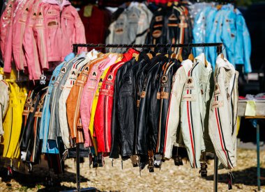 Faaker See, Avusturya - 01 Eylül 2025: Canlı deri ceketler Avrupa Bisiklet Haftası 'nda askıda asılı, hareketli bir pazarda çeşitli renkleri ve stilleri vurguluyor