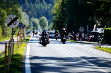 Faaker See, Avusturya - 01 Eylül 2025: Motosikletçiler Avrupa Bisiklet Haftası boyunca yol manzaralı yolculuğun keyfini çıkarırken, canlı toplum ruhu ve heyecanını yakaladılar