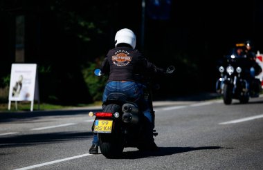 Faaker See, Avusturya - 01 Eylül 2025: Harley-Davidson deri ceketli motosiklet sürücüsü Avrupa Bisiklet Haftası boyunca manzaranın tadını çıkararak macera ruhunu yakaladı
