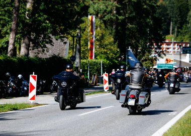 Faaker See, Avusturya - 01 Eylül 2025: Motosikletliler Avrupa Bisiklet Haftası boyunca Harley-Davidson motosikletleri ve güzel çevresinin yer aldığı manzaralı yolculukların tadını çıkarıyorlar