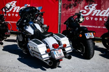 Faaker See, Avusturya - 01 Eylül 2025: Harley-Davidson bisikleti Avrupa Bisiklet Haftası 'nda park edilmiş, arka planda Hint Motosiklet afişi bulunan krom aksanlar ve canlı renklerle
