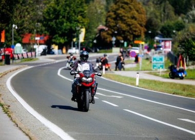 Faaker See, Avusturya - 01 Eylül 2025: Avrupa Bisiklet Haftası boyunca virajlı yolda motorsikletli gezginler etkinliğin keyfini çıkarıyorlar