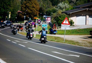 Faaker See, Avusturya - 01 Eylül 2025: Harley-Davidson bisikletli motosikletçiler Avrupa Bisiklet Haftası boyunca doğa ve canlı manzarayla çevrili, pitoresk bir yolda seyahat ediyorlar