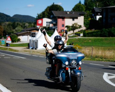 Faaker See, Avusturya - 01 Eylül 2025: Harley-Davidson sürücüleri Avrupa Bisiklet Haftası 'nı kutluyorlar, güzel manzaralı ve neşeli bir ortam ile manzaralı bir yolda seyahat ediyorlar.