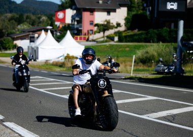 Faaker See, Avusturya - 01 Eylül 2025: Genç adam Avrupa Bisiklet Haftası 'nda özel motosiklet sürmekten hoşlanıyor, Harley-Treffen' in heyecanını ve enerjisini yakalıyor