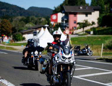 Faaker See, Avusturya - 01 Eylül 2025: Avrupa Bisiklet Haftası 'nda motosiklet sürerken motor meraklısı dalgalar, manzaralı manzaralar ve festival atmosferiyle çevrili