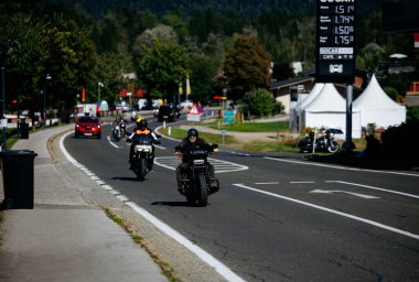 Faaker See, Avusturya - 01 Eylül 2025: Motosikletçiler Avrupa Bisiklet Haftası 'nda Harley-Davidson bisikletlerinin ve canlı çevrenin yer aldığı pitoresk bir yolda ilerliyorlar