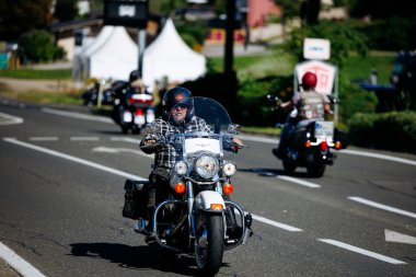 Faaker See, Avusturya - 01 Eylül 2025: Avrupa Bisiklet Haftası 'nda sakallı bisikletçi Harley-Davidson motosiklet sürüşü