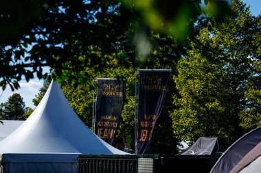 Faaker See, Avusturya - 01 Eylül 2025: Avrupa Bisiklet Haftası afişleri ağaçlar arasında görülebiliyor, Harley-Treffen 'deki canlı motosiklet kültürünü vurguluyorlar