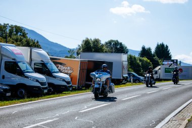 Faaker See, Avusturya - 01 Eylül 2025: Harley-Davidson motosikletleriyle Avrupa Bisiklet Haftası boyunca resimli bir yolda seyahat eden motosikletçiler, özgürlük ve macera ruhunu yakaladılar