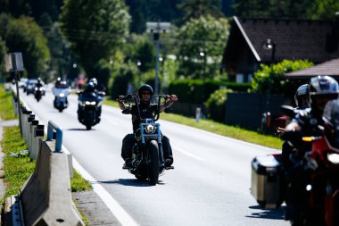 Faaker See, Avusturya - 01 Eylül 2025: Harley-Davidson motosikletleri Avrupa Bisiklet Haftası 'nın ruhunu ve macera heyecanını yansıtan pitoresk bir yolda birlikte seyahat ediyorlar.