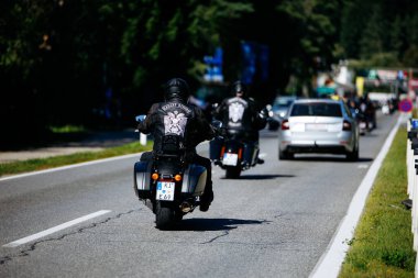 Faaker See, Avusturya - 01 Eylül 2025: Avrupa Bisiklet Haftası boyunca deri kıyafetli motosikletliler resmi bir yolda gezinerek Harley-Treffen 'in ruhunu yakaladılar